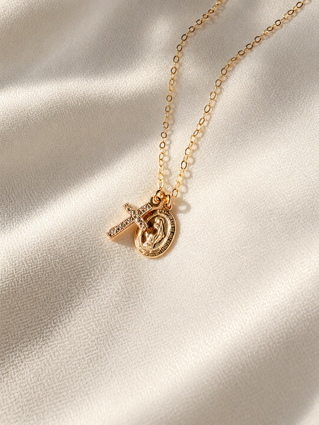 Dainty 14K gold filled Virgin Mary and cross necklace featuring an oval 9x13mm Mary medal and tiny 8x15mm cross on a delicate gold chain.