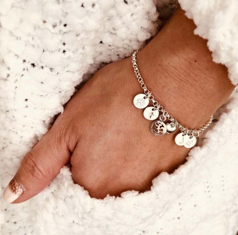 Personalized sterling silver initial charm bracelet with hand stamped discs and charms

Sterling silver personalized bracelet with initial, heart, cross, paw charm 