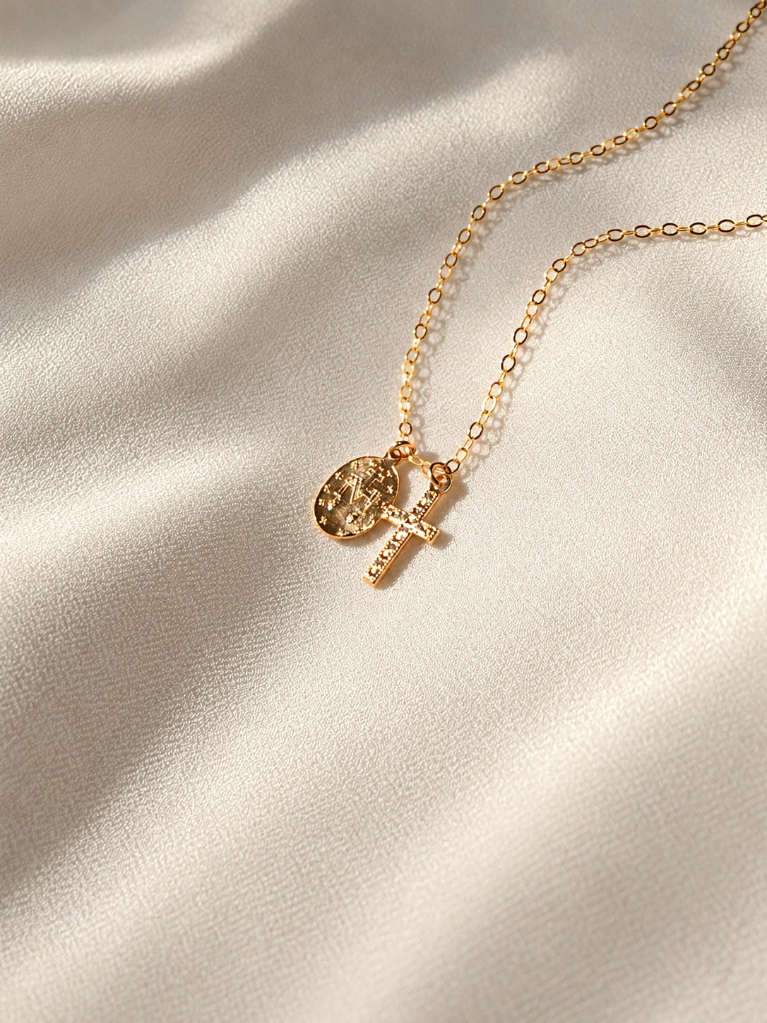 Back view of double-sided Virgin Mary medal and cross charms on a delicate 14K gold filled religious necklace.