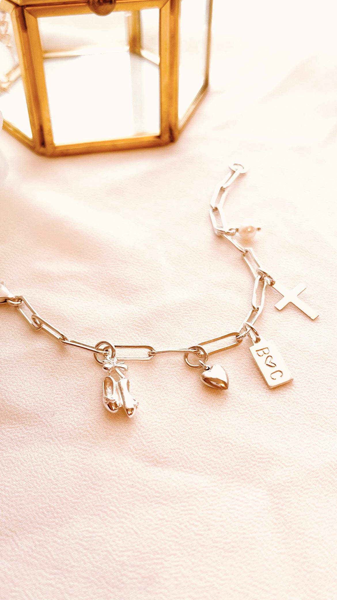 Personalized sterling silver charm bracelet worn on wrist with heart initial tag and paw print charm Gift for dance 