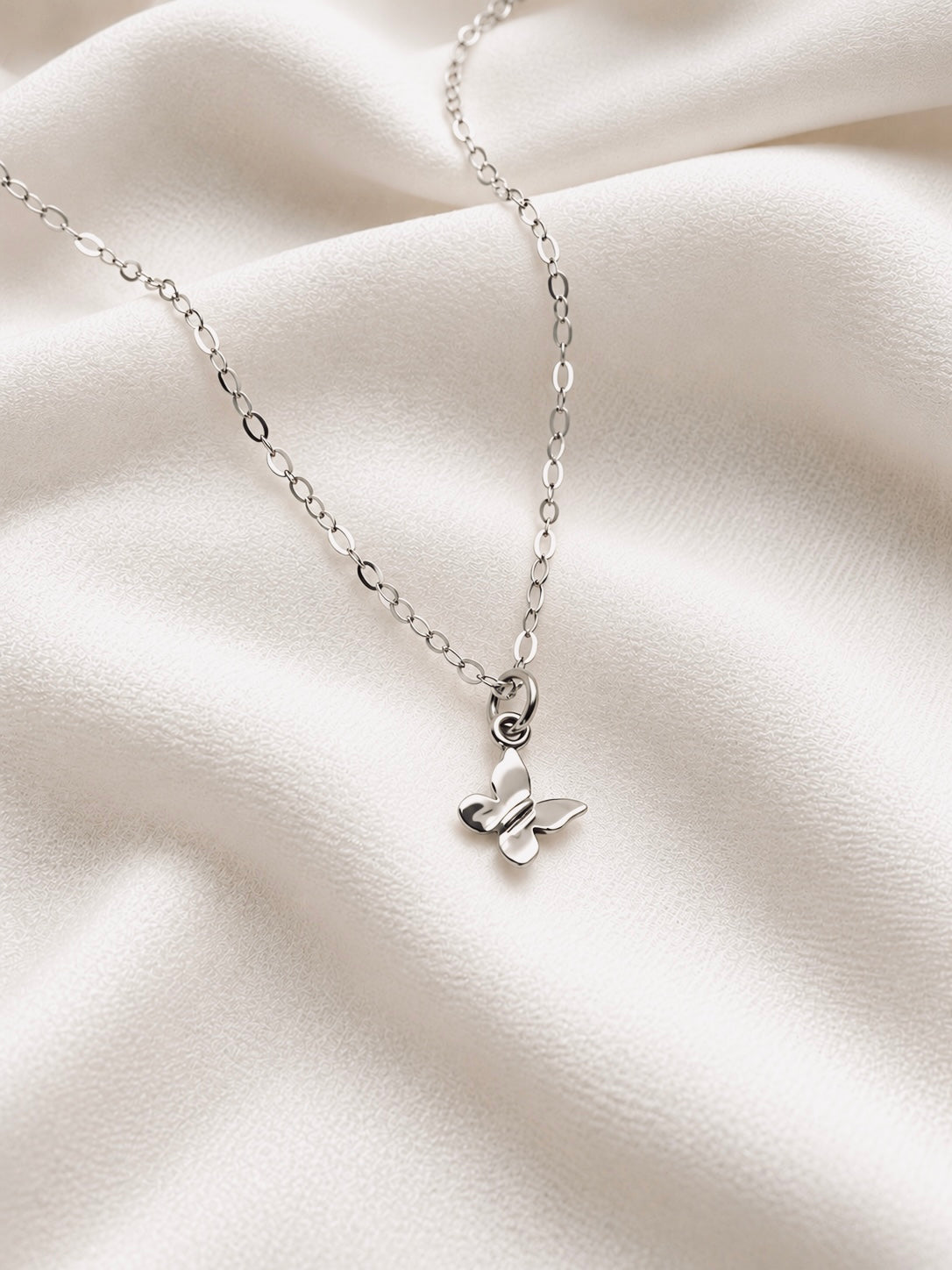 Tiny sterling silver butterfly necklace with delicate silver chain, minimalist lightweight everyday jewelry.

