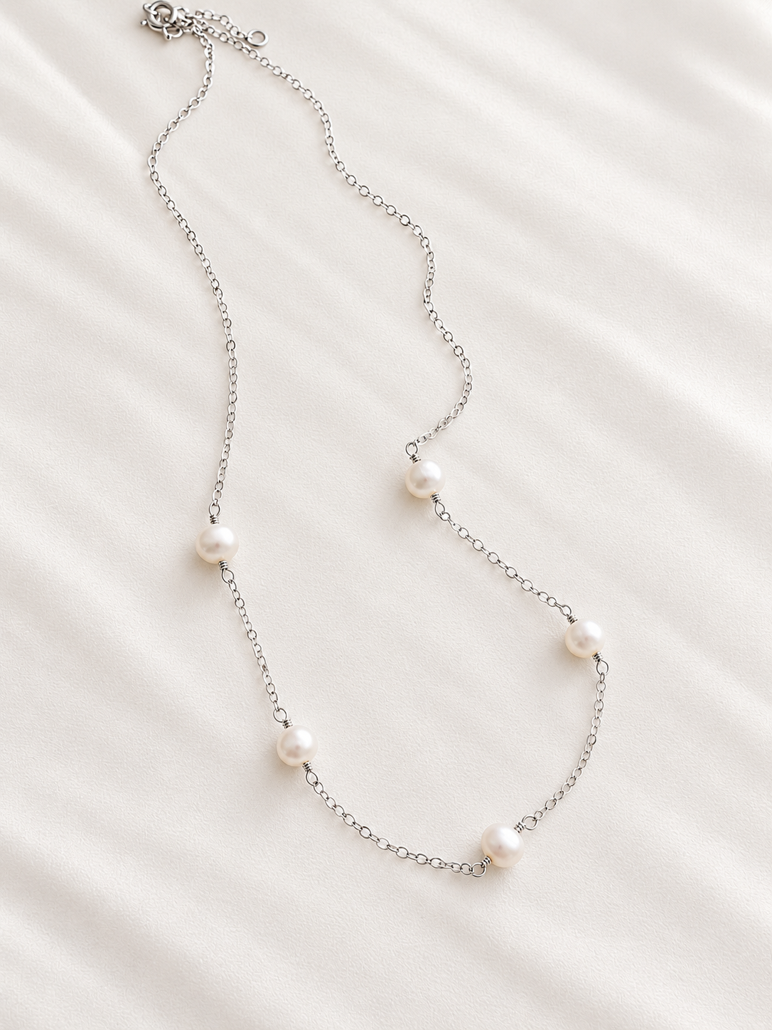This ultra-dainty sterling silver necklace features freshwater pearls delicately spaced along a fine chain for a simple, feminine look.

Each freshwater pearl is naturally unique in shape, texture, and luster—making every necklace one of a kind.
