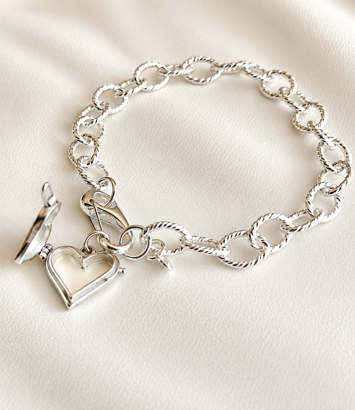 Sterling Silver Heart Locket Charm Bracelet | Removable Heart Charm, Made with sterling silver, this charm bracelet features a beautiful openable heart locket charm that can be removed or changed whenever you like. Wear it simply with the heart locket or add your favorite charms to create a bracelet that tells your own story. Open sterling silver heart locket charm on silver link bracelet