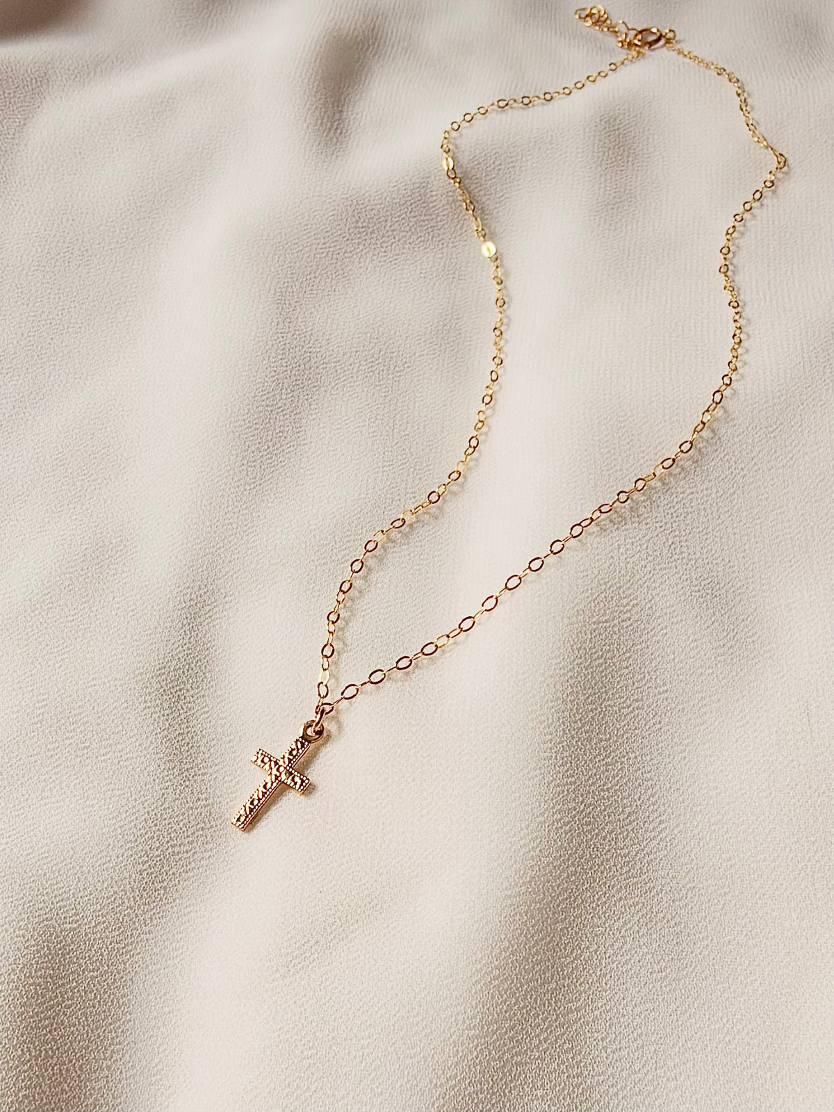 **14K Gold Filled Cross Necklace** features a tiny 8 × 15mm double\-sided cross charm on a delicate gold filled chain\. Beautifully detailed on both sides, this minimalist religious necklace is a meaningful reminder of faith, love, and strength\.