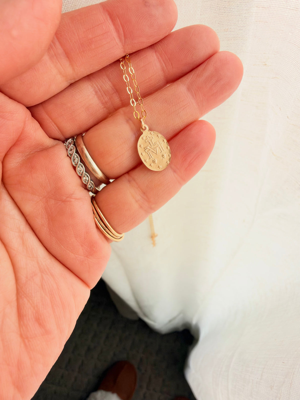 Full view of dainty 14K gold filled Virgin Mary necklace with tiny oval religious charm, perfect for everyday wear and layering. Made from Coco Wagner Design 