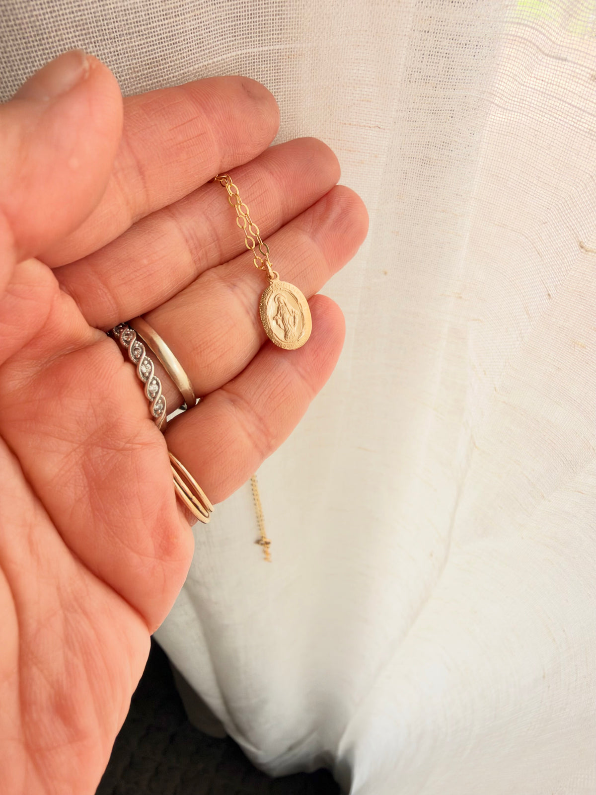 Full view of dainty 14K gold filled Virgin Mary necklace with tiny oval religious charm, perfect for everyday wear and layering.