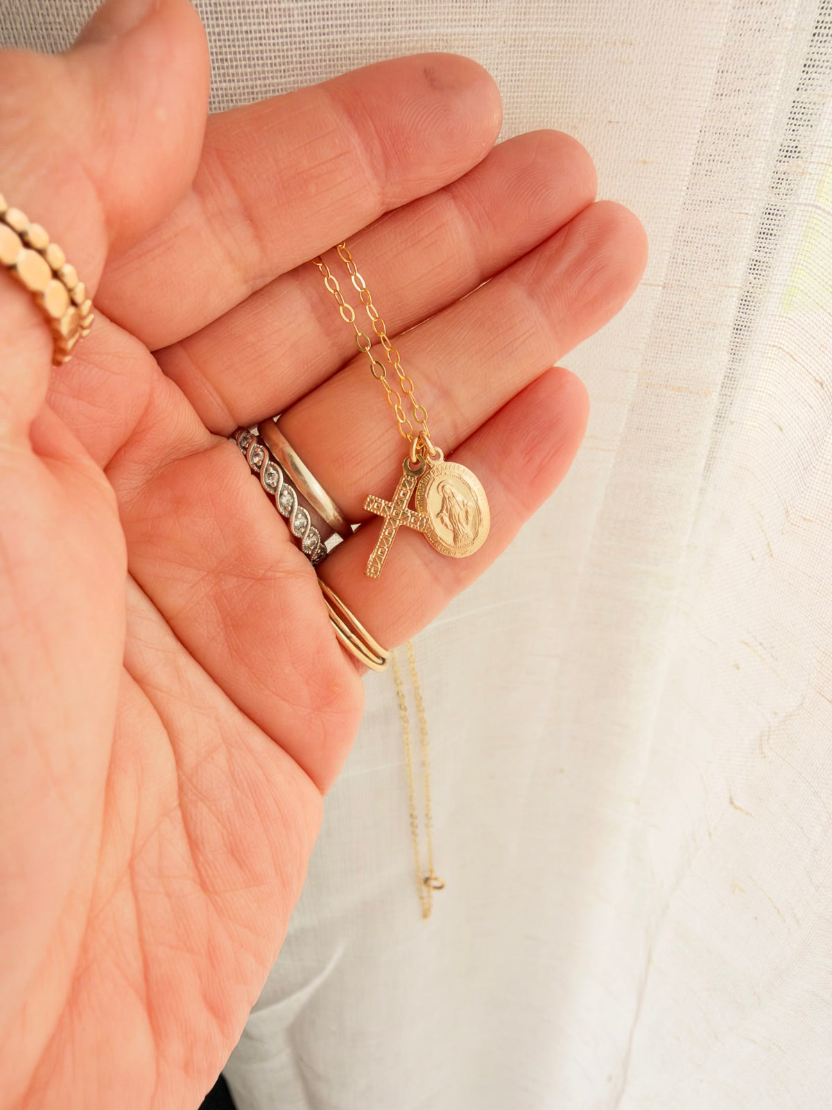 A dainty 14K Gold Filled Virgin Mary and Cross Necklace featuring two double-sided charms. Lightweight, meaningful religious jewelry for everyday wear.